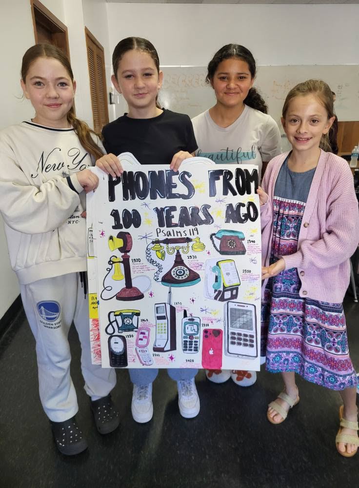 Academy students holding a class project poster