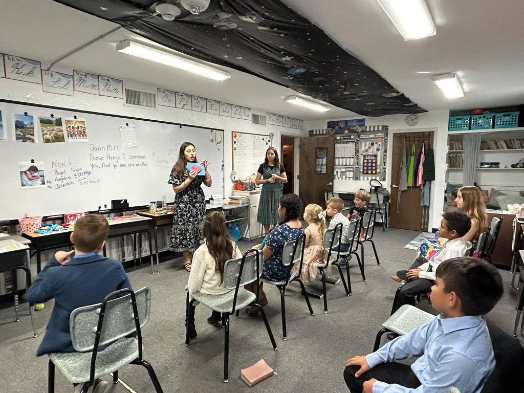 Young women teaching a class of children at the church