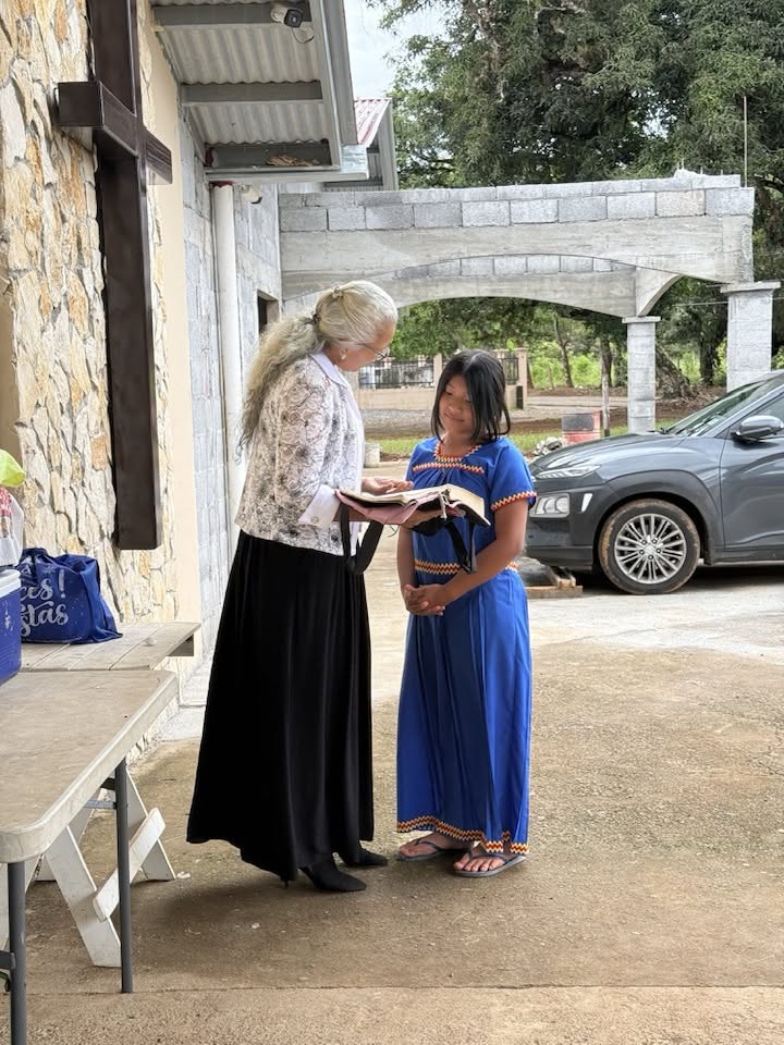 A missionary woman sharing the Bible with a young girl in Panama