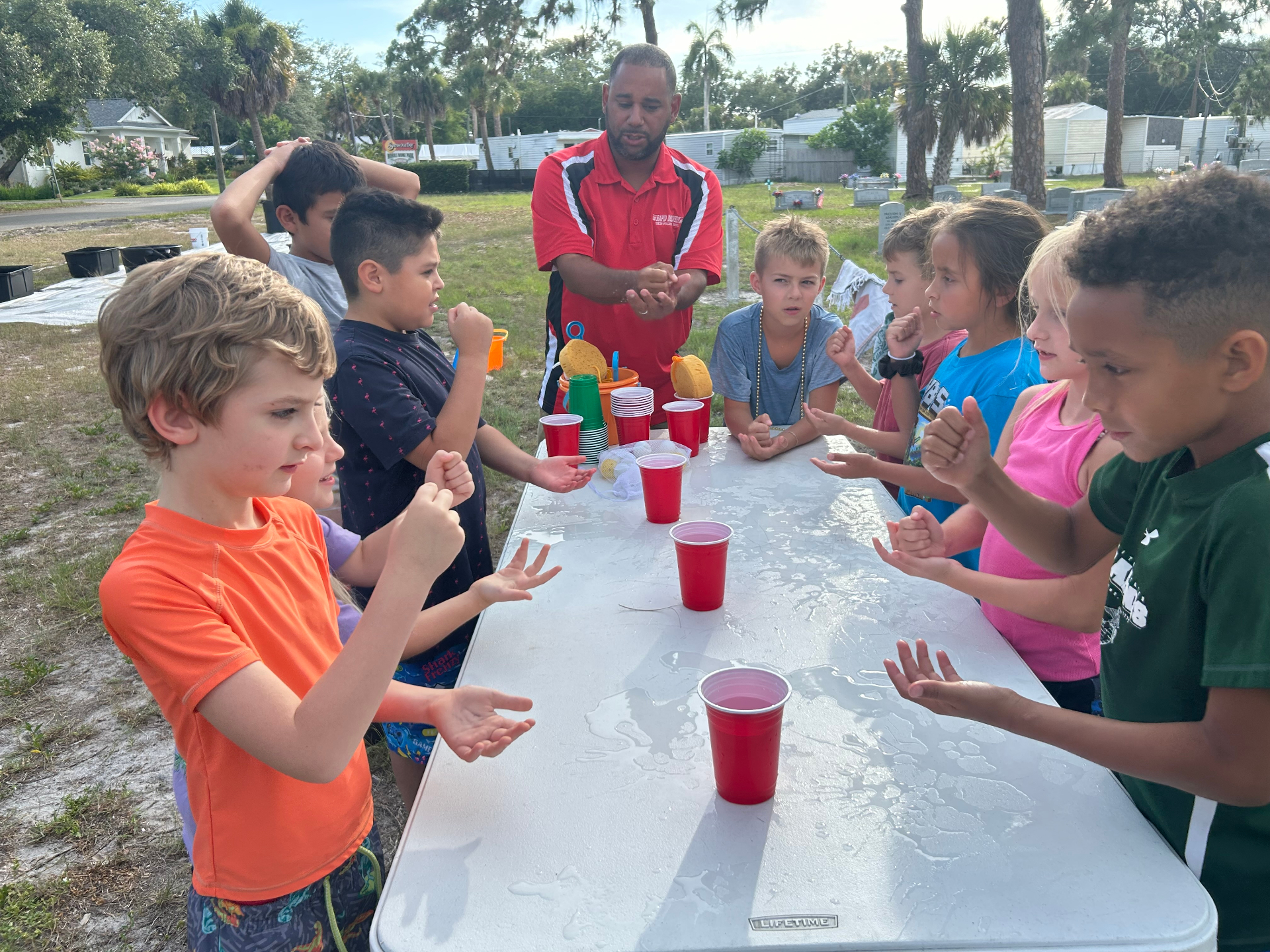 Children playing a game around an outdoor table